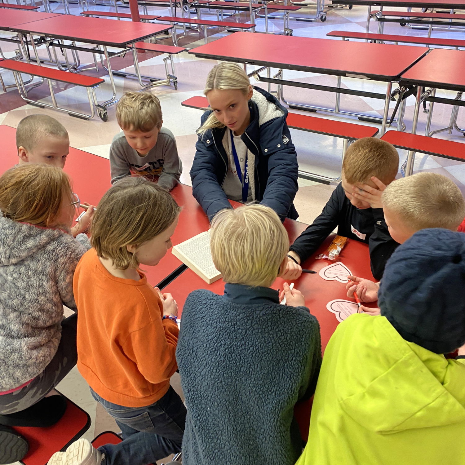 Children at a red table learning a bible lesson