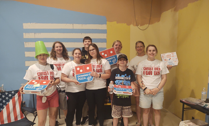 Group of children posing with pizza signs