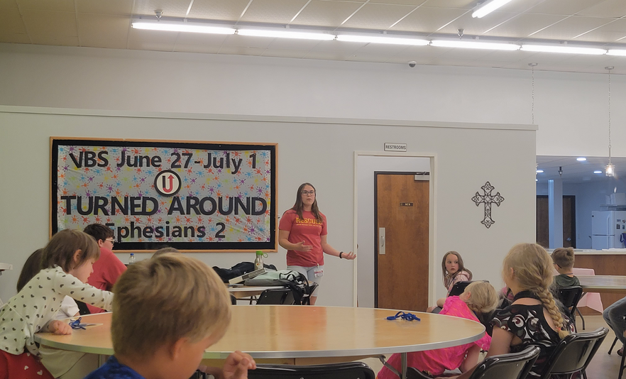 a gathering of children listening to a presentation